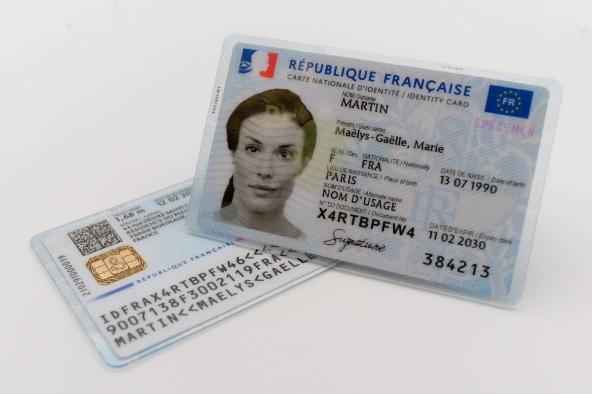 French ID card showing front and back design on a table with French flag